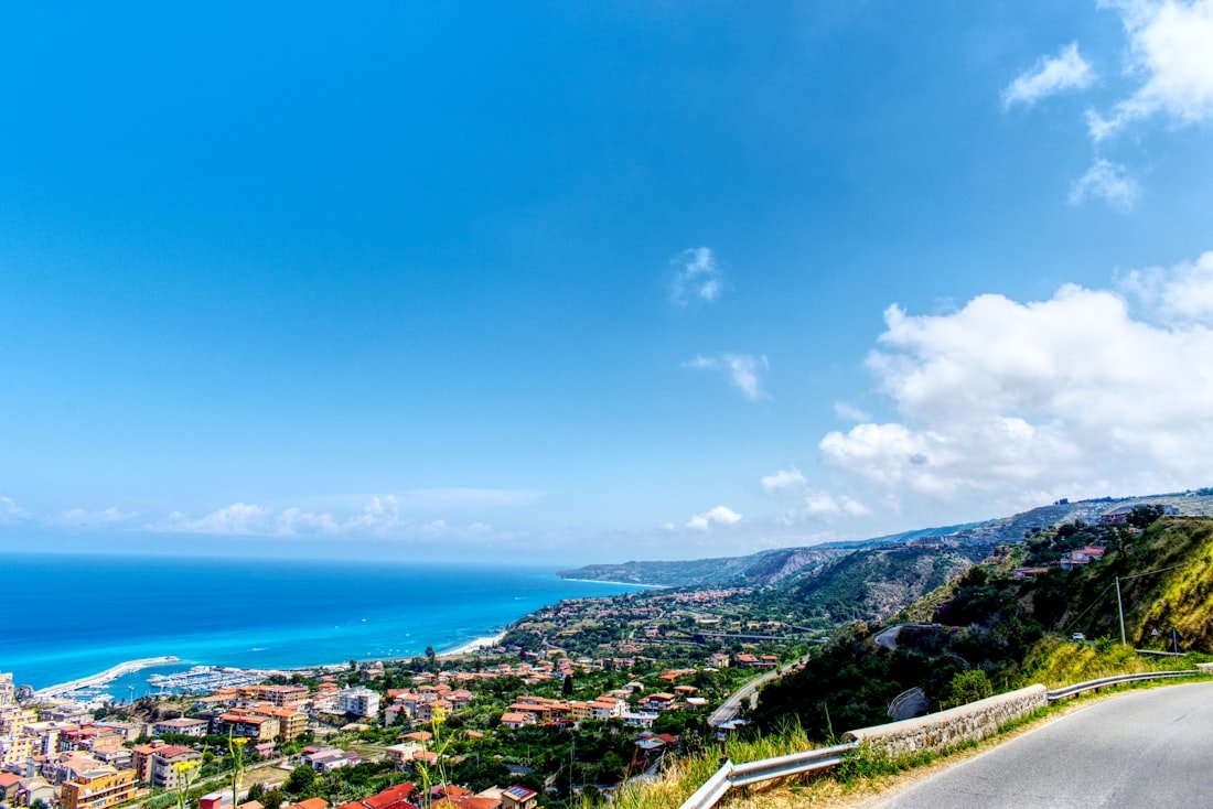 A Calabrian seaside town on turquoise water beneath green hills