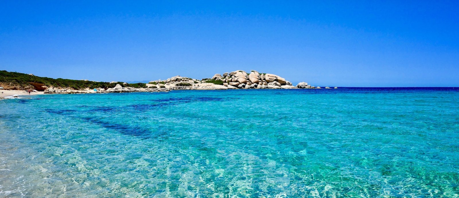 Crystal-clear turquoise shallows over white sand on the coast of Sardinia